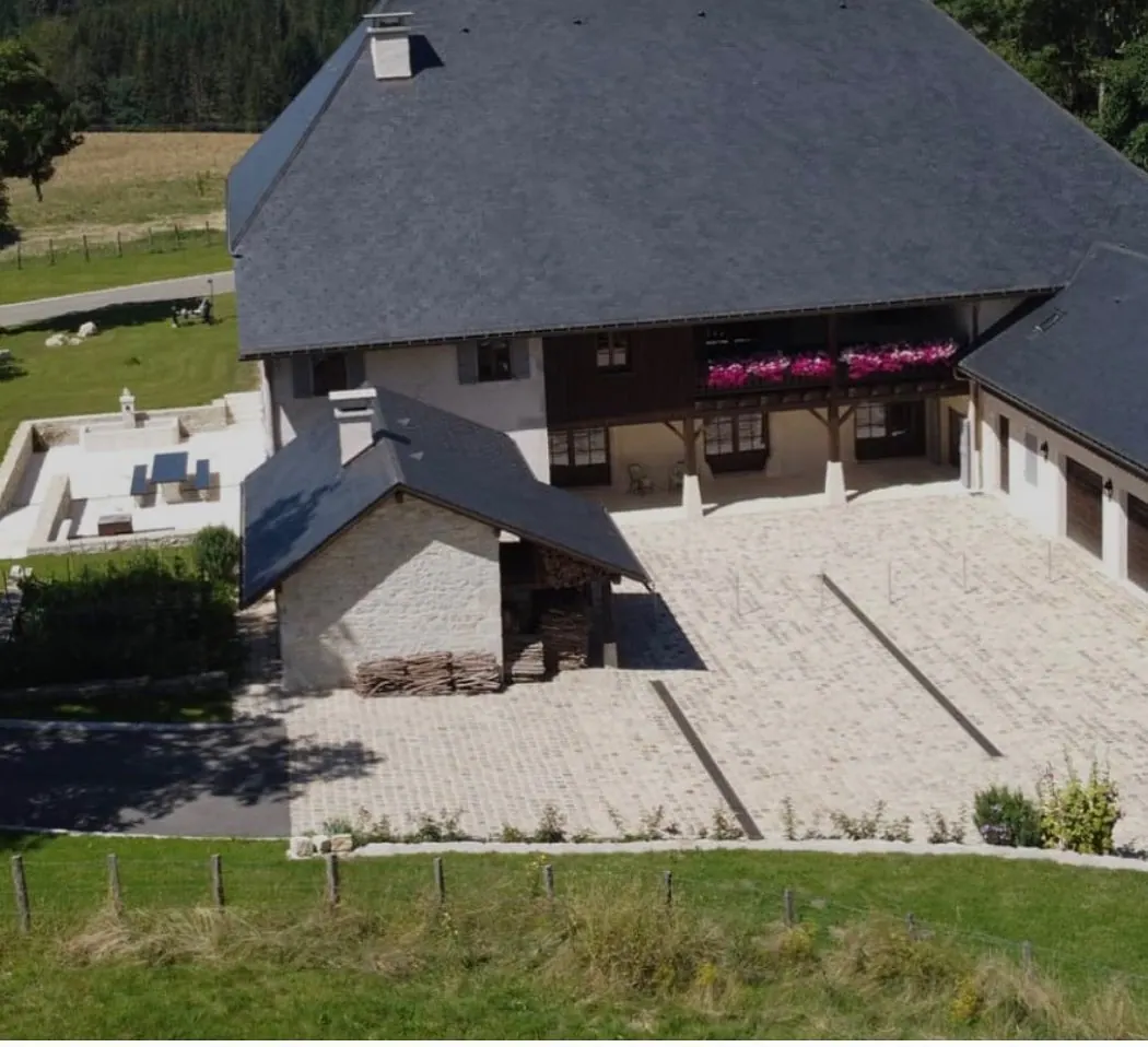 Vue aérienne d'un corps de ferme réhabilité et de sa cour minérale